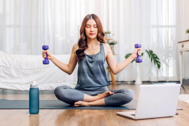 Portre sporu spor, spor kıyafetleri içinde ince kadın, rahatlama ve yoga yapan kız, yatak odasında dizüstü bilgisayarla spor yapıyor. Diyet konsepti. Fitness ve sağlıklı.