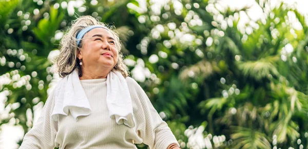 快乐的老年老年亚洲老年妇女的画像 她们微笑着站着 张开胳膊 享受着大自然的气息 在绿地里呼吸着新鲜清新的空气 — 图库照片