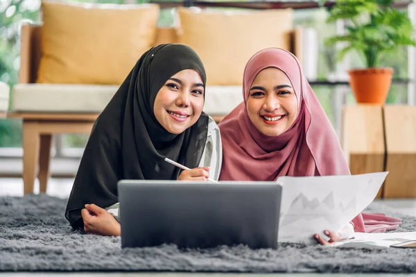 stock image Young two smiling happy beautiful asian muslim woman relaxing using laptop computer working and meeting analyzing discussing strategy with startup project plan and brainstorm at home