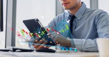 İş dünyasının finansal yatırım verilerinin ekran gelişimine bakan teknoloji dijital tablet bilgisayarı kullanarak rahatlayan hippi iş adamı, ofisteki iş büyümesi grafiğini ve grafiğini çıkarıyor.