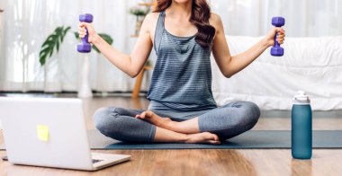 Portre sporu spor, spor kıyafetleri içinde ince kadın, rahatlama ve yoga yapan kız, yatak odasında dizüstü bilgisayarla spor yapıyor. Diyet konsepti. Fitness ve sağlıklı.