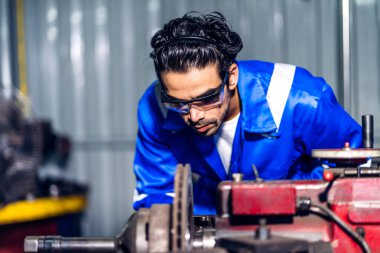 Profesyonel iş gücü mühendisi teknisyeni mavi güvenlik üniforması giyen işçi işçi fabrika üretim hattında ağır makinelerle çalışıyor. İş sektörü.