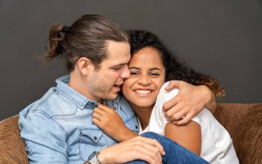 Romantik, genç, mutlu, beyaz erkek ve Afrikalı Amerikalı kadın Sevgililer Günü 'nde siyah arka planda gülümseyip eğleniyorlar.