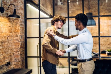 İmaj iki iş ortağının başarılı bir tokalaşmayla birlikte başarılı bir şekilde el sıkışması modern ofisin iyi bir anlaşmasını kutluyor. Ortaklık onayı ve takım çalışması konsepti