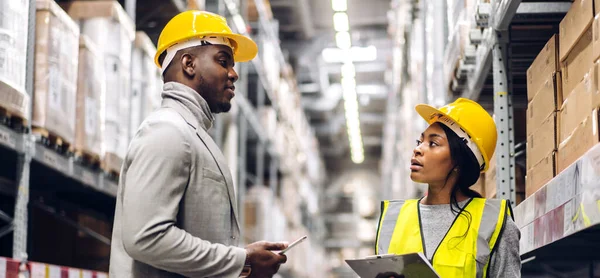 Portrait two african american engineer team shipping order detail on tablet check goods and supplies on shelves with goods inventory in factory warehouse.logistic industry and business export