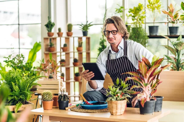 Mutlu bahçıvan kıdemli yaşlı adam bahçedeki küçük ağaçla ilgilenen çiçek sulama ve bahçeyle bahçeye bakıyor. Emeklilik kavramı.