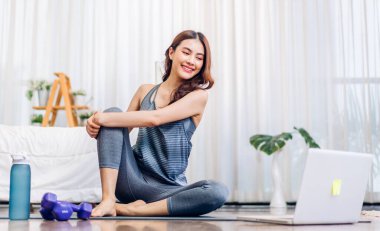 Portre sporu spor, spor kıyafetleri içinde ince kadın, rahatlama ve yoga yapan kız, yatak odasında dizüstü bilgisayarla spor yapıyor. Diyet konsepti. Fitness ve sağlıklı.