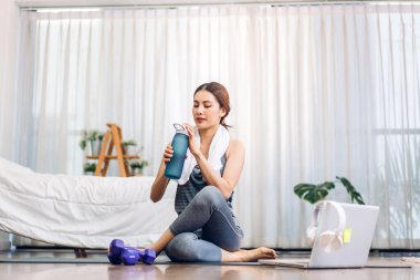 Portre sporu spor, spor kıyafetleri içinde ince kadın, rahatlama ve yoga yapan kız, yatak odasında dizüstü bilgisayarla spor yapıyor. Diyet konsepti. Fitness ve sağlıklı.