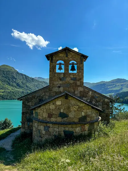 Kilise, turkuaz suyla göl, bulutlar ve mavi gökyüzü.