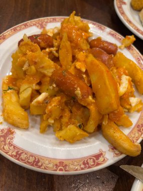 Patates kızartmalı İspanyol mezesi, kızarmış yumurta ve sosis.