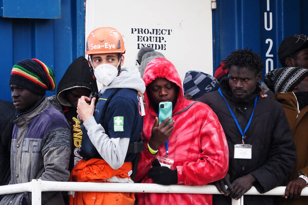 Мигранты ждут, чтобы покинуть корабль. Немецкое спасательное судно "Морской глаз-4" прибывает в порт Неаполя со 109 мигрантами на борту, в том числе 35 несовершеннолетних, 18 женщин, одна из которых беременна, а две мертвы.