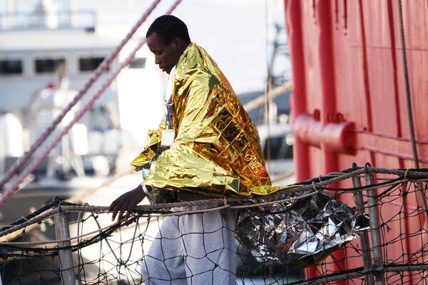 Мигрант покидает корабль. Немецкое спасательное судно "Морской глаз-4" прибывает в порт Неаполя со 109 мигрантами на борту, в том числе 35 несовершеннолетних, 18 женщин, одна из которых беременна, а две мертвы.