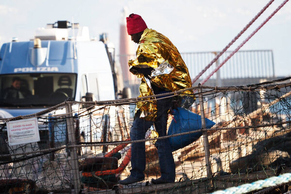 Мигрант покидает корабль. Немецкое спасательное судно "Морской глаз-4" прибывает в порт Неаполя со 109 мигрантами на борту, в том числе 35 несовершеннолетних, 18 женщин, одна из которых беременна, а две мертвы.