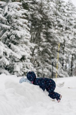 Karda oynayan 3 yaşındaki küçük kız.