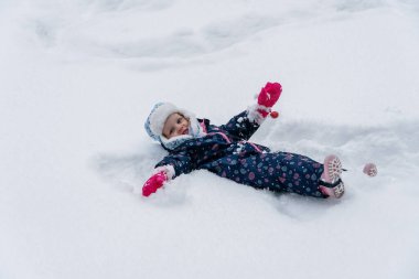 Karda oynayan 3 yaşındaki küçük kız.