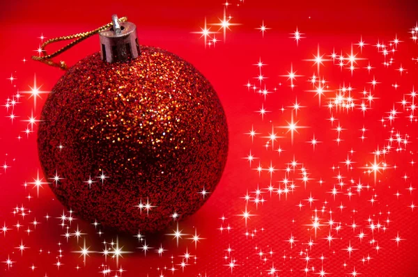 Kırmızı Arka Planda Parlayan Yıldızlarla Çevrili Bir Noel Topu Noel — Stok fotoğraf