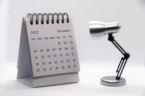 テーブルランプと白の背景に2022年12月ホワイトデスクカレンダー カレンダーのコンセプト — ストック写真