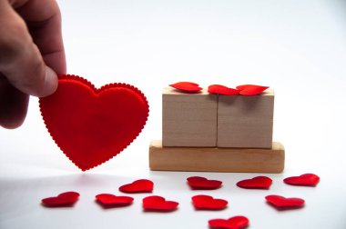 Boş kalp şeklini tutan boş tahta bloğu olan, arka planda kişiselleştirilebilir metin alanı olan bir el. İlişki kutlaması konsepti ve kopyalama alanı.