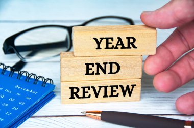 Aralık takvimi, gözlükler ve kalemle ahşap bloklarla ilgili yıl sonu inceleme metni. Yıl sonu inceleme kavramı.