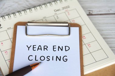 Aralık takvimine sahip beyaz not defterindeki yıl sonu kapanış metni. Yıl sonu kapanış kavramı.