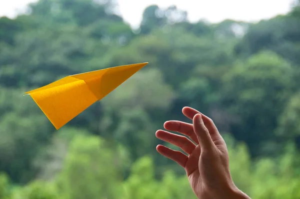 Hand Catching Flying Yellow Paper Plane Green Nature Background Royalty Free Stock Images