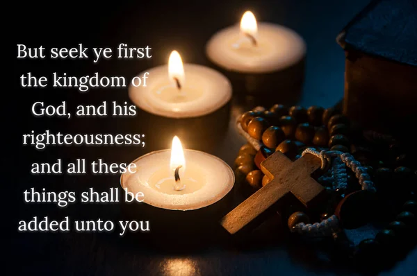 Christian prayer text on seeking the Kingdom of God with Holy Rosary, Bible and burning candles background. Christian prayer and religion concept.