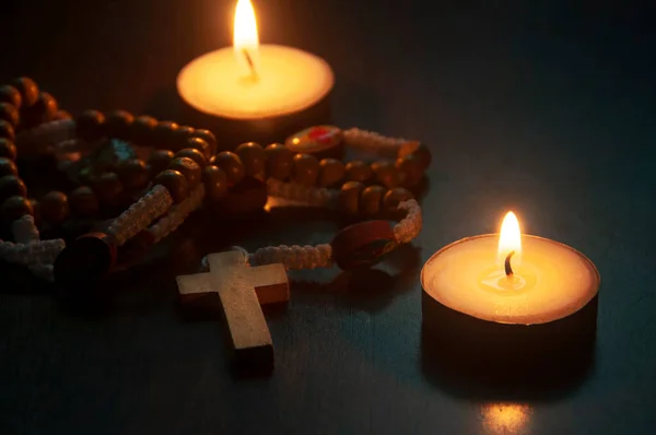 Holy Rosary and burning candles with customizable space for religious text or ideas. Copy space and religion concept.
