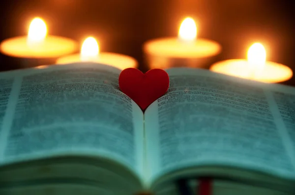 Red heart shape on Holy Bible with customizable space for text or ideas. Copy space.