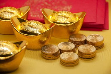 Çin Yeni Yıl paketleri Çin altınları ve sarı arka planda altın sikkeler.