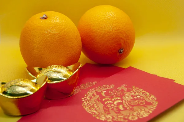 黄色のカバーの背景にオレンジ 赤のパケットと金のインゴットと中国の旧正月の装飾 中国のお祝いの季節のコンセプト — ストック写真