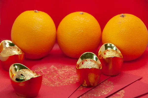 Китайские Новогодние Украшения Апельсинами Красными Пакетами Золотыми Слитками Фоне Красной — стоковое фото