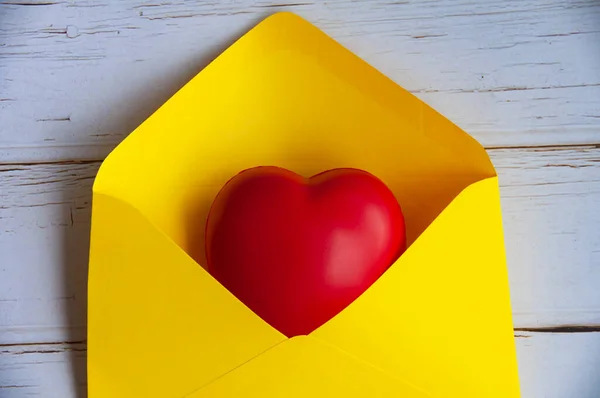 Love letter with heart shape sheet in yellow paper envelope. Love concept and copy space.