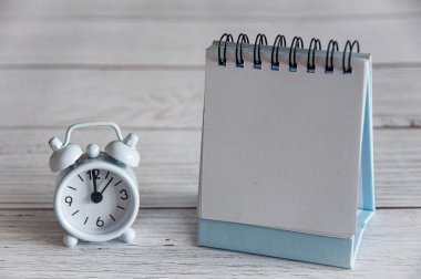 Empty table calendar and alarm clock with customizable space for text or message. Copy space and business concept.