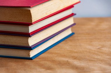 Stacks of books on wooden table with customizable space for text. Copy space.