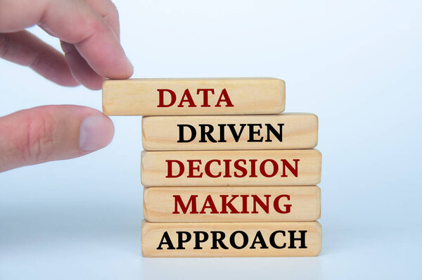 Hand holding wooden block with text Data Driven Decision Making Approach text on wooden blocks. Business culture and Operational excellence concept.