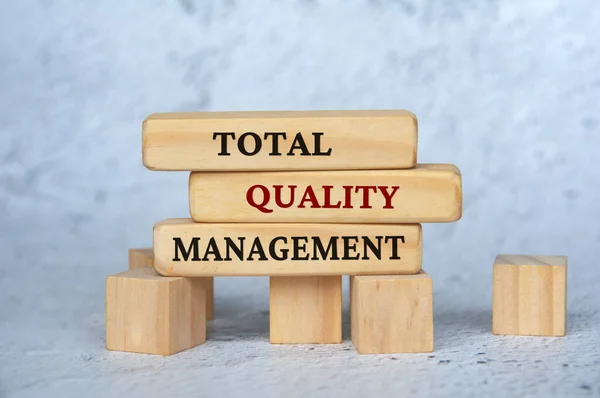 Total quality management text on wooden blocks. Business management concept.