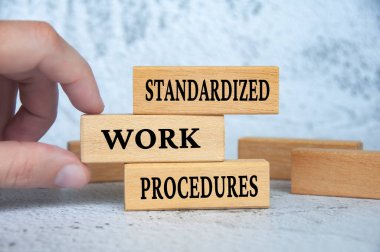 Standart çalışma prosedürleri ahşap bloklarda yazılı. İş konsepti.