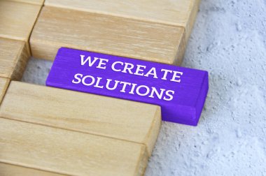 Top view of text - we create solutions text on blue wooden block separated from the rest of the blocks. clipart