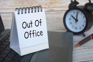 Out of office notification text on white notepad. Out of Office concept. clipart