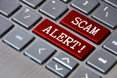 Scam Alert text on laptop keyboard. Scam and fraud concept. clipart