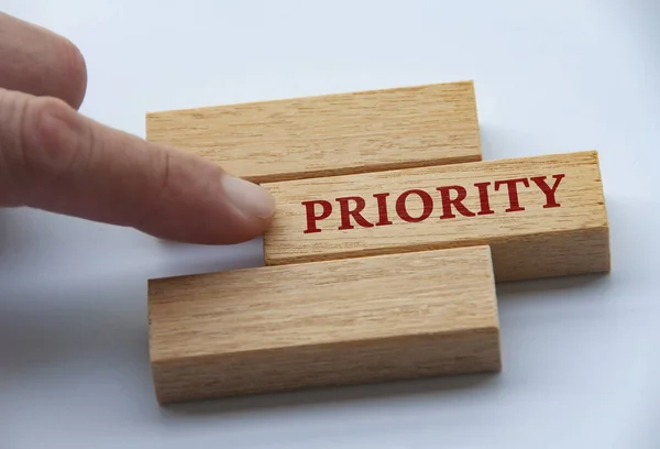 stock image Finger pushing wooden blocks with text - Priority. Priority and business concept.