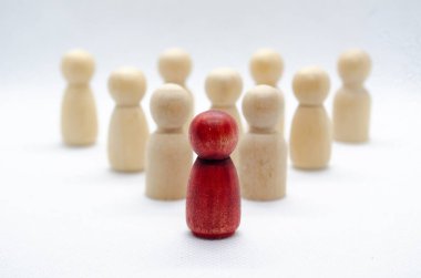 Diğer ahşap figürlerin ulaştığı kırmızı ahşap figürlere yaklaş. Liderlik kavramı.
