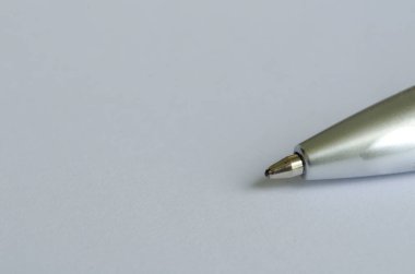 Metin veya fikirler için özelleştirilebilir alanı olan beyaz not defterindeki gümüş kalemin yakın plan görüntüsü