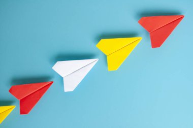 Kırmızı kağıttan uçak origamisinin üst görüntüsü diğer kağıt uçaklara öncülük ediyor. Metin için kopyalama alanı ile