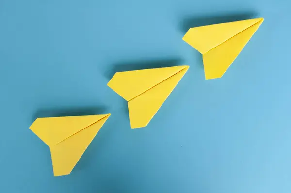 Top view of yellow paper airplanes with space for text.