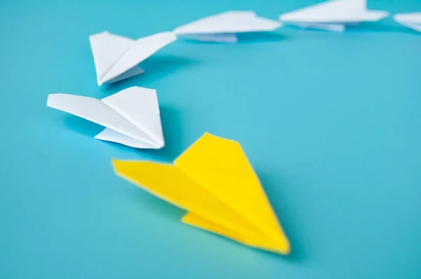 Side view of yellow paper airplane origami leading white paper airplanes. Leadership and copy space concept.