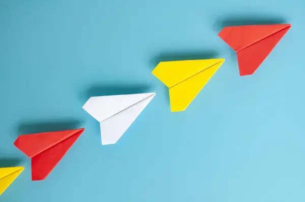Top view of red paper airplane origami leading other paper airplanes. With copy space for text