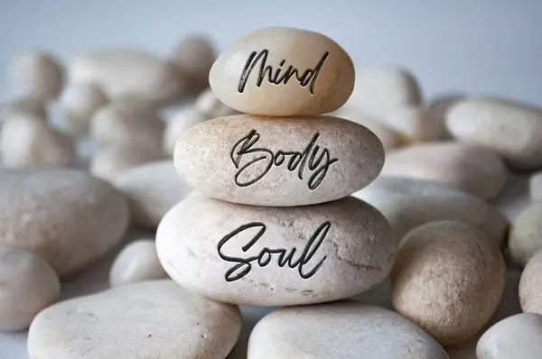 Mind, Body and soul text engraved on white zen stones.