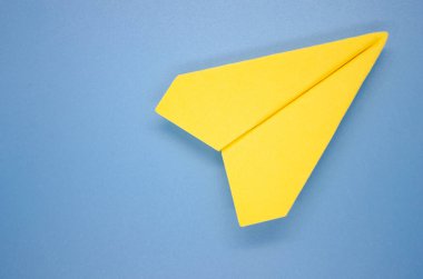 Mavi zemin üzerinde sarı kağıt uçak üst görünümü yazı için özelleştirilebilir alan. Boşluğu kopyala.