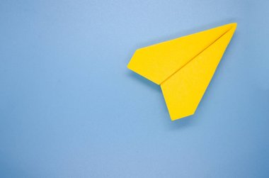 Mavi zemin üzerinde sarı kağıt uçak üst görünümü yazı için özelleştirilebilir alan. Alan ve düzlem konseptini kopyala